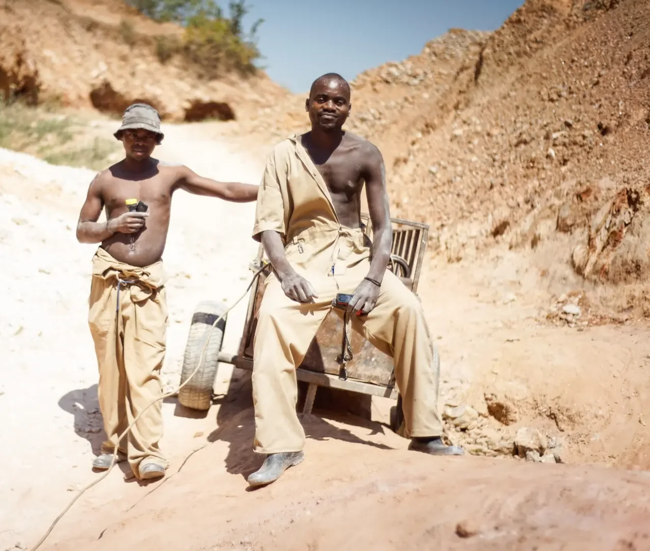 Two artisanal miners with their cart at a mine site